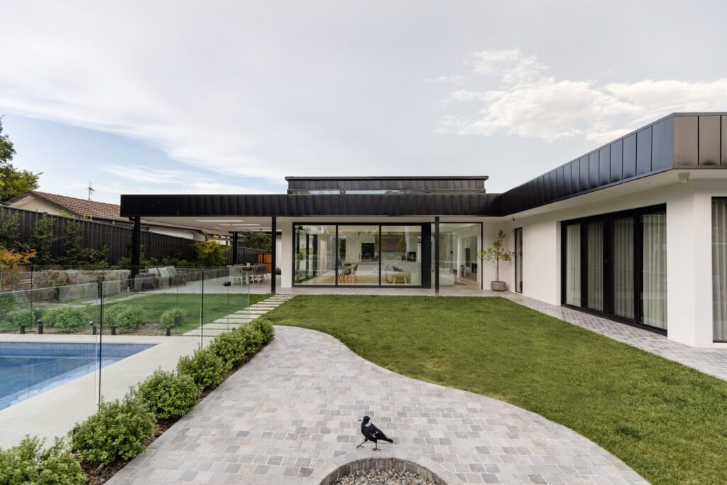 Dark aluminium windows and doors overlooking the landscaped garden at Pearce Residence