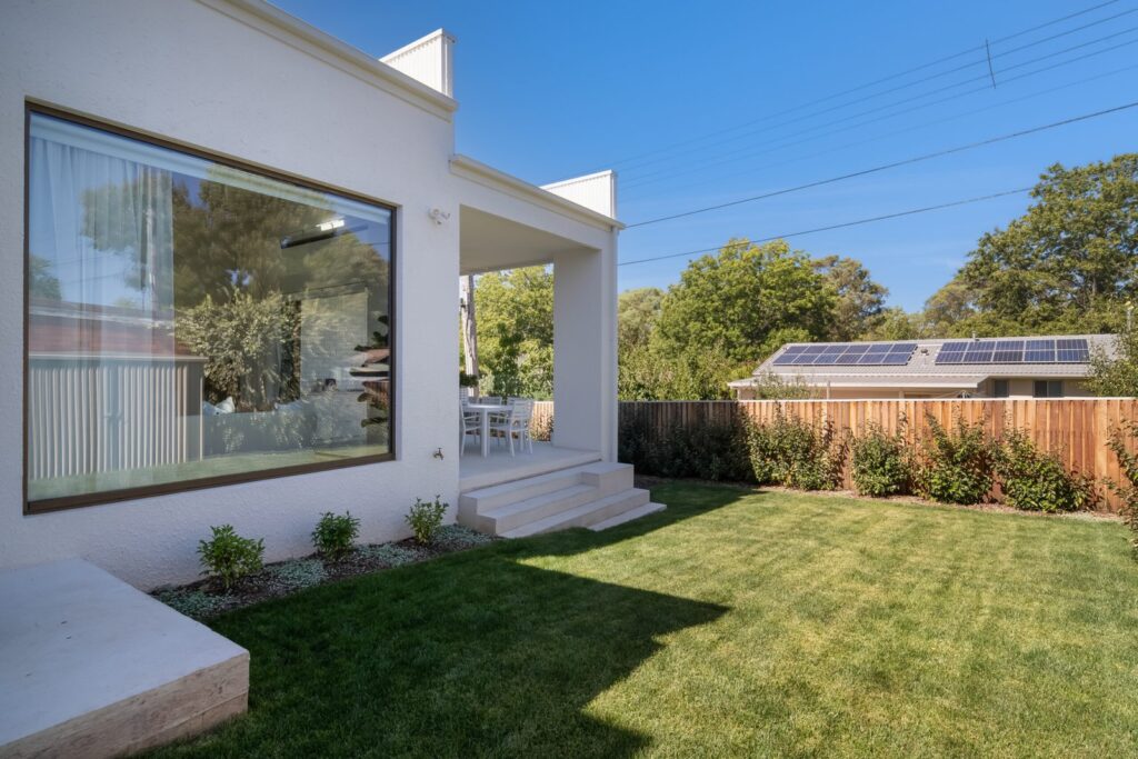 Natural bronze picture window overlooking the backyard at the Curtin Duplex