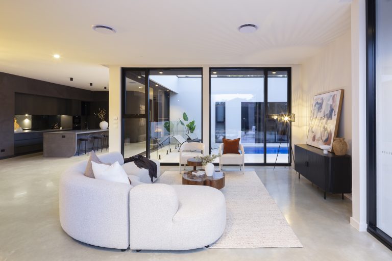 Aluminium-framed glazing connecting the Downer residence living room with its courtyard and pool