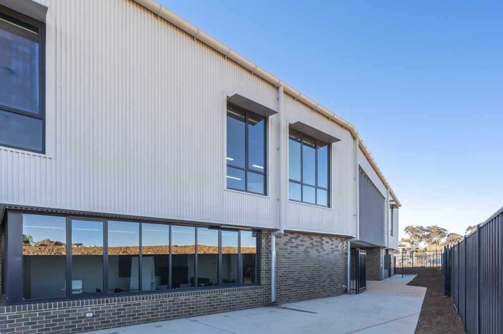 Dark aluminium windows along the corrugated facade of Margaret Hendry School expansion