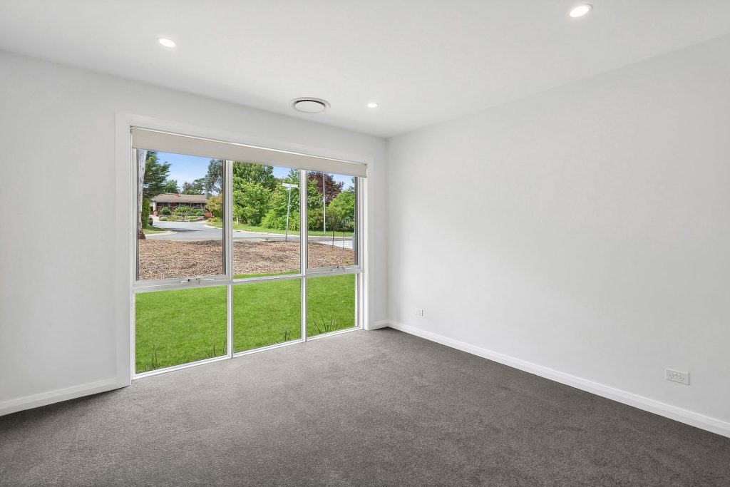 White-framed residential window overlooking a green garden at a Higgins home, installed by Performance Windows.