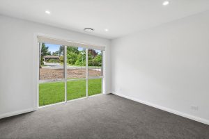 White-framed residential window overlooking a green garden at a Higgins home, installed by Performance Windows.